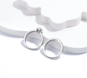 Detailansicht des S925 Silber Ringsets mit Zirkonia-Schneeflocke auf weißer Geometrie