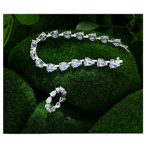 Parure bracelet et bague avec diamants poire sur fond de mousse verte naturelle