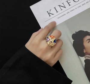 Detailed view of luxury multi-color gemstone ring on model with Kinfolk magazine backdrop