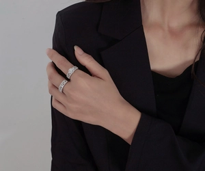 Detail of stacked s925 silver snowflake rings with zircon on model in black suit