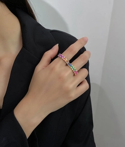 Macro shot of silver ring featuring multi-color trapezoid cut gradient zircons on hand