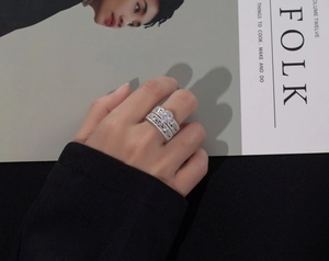 Close-up of a silver snowflake zircon ring set worn by a model over a lifestyle magazine