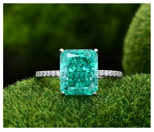 Vue macro d'une bague avec pierre verte taille émeraude et anneau serti de diamants