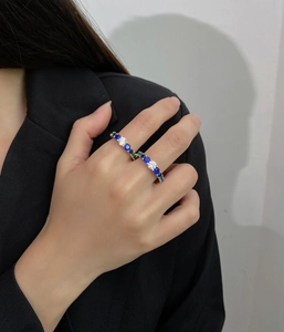 Detail of stacked eternity rings with multi-color zircon stones and gold plating