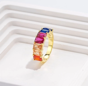 Detail of gold plated ring with multicolor rectangular gemstones in a 4-prong setting