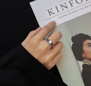 Detail of hand wearing gold ring with multi-color zircon stones on Kinfolk magazine