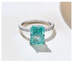 Macro shot of rectangular emerald cut gemstone on a sparkling silver pave band ring