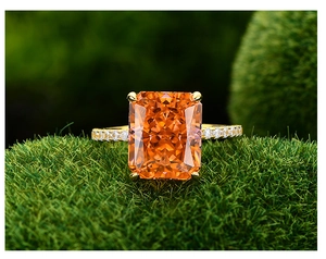 Vue macro d'une bague avec pierre orange rectangulaire et diamants pavés sur mousse