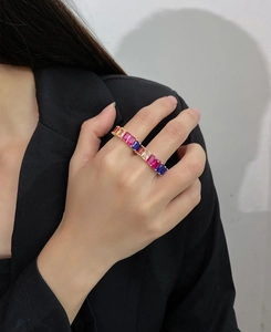 Macro detail of a 4x6mm multi-colored rectangular gemstone row ring in a gold setting