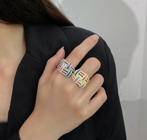 Macro detail of hand wearing 925 silver wide rings with colorful pavé gemstones