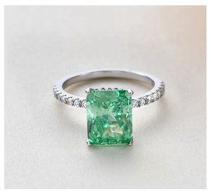 Detailed macro view of S925 silver ring featuring emerald cut green gemstone and pavé diamonds