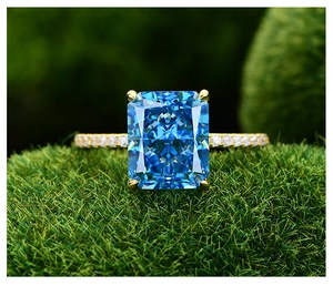 Détail macro d'une bague saphir taille radiant avec anneau pavé doré sur mousse