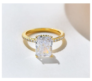 Macro detail of rectangle ice-cut clear gemstone on sparkling gold-plated silver ring