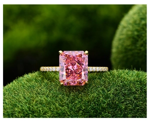 Vue macro d'une bague avec pierre rose taille radiant et diamants pavés sur de la mousse