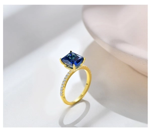 Macro shot of 925 silver ring with blue emerald cut stone and side diamond accents