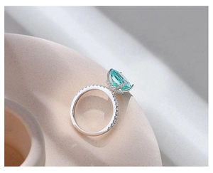 Macro detail of ice-cut light blue gemstone ring with micro-pave diamonds on silver band
