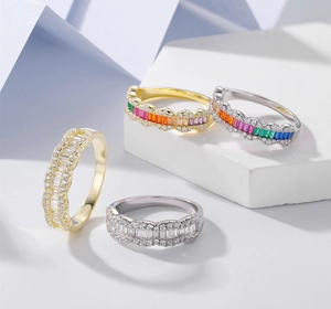 Detailed view of wave-edged 925 silver rings with baguette-cut rainbow gems on stone