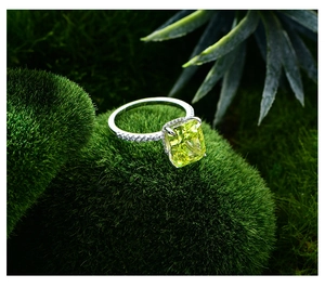 Gros plan d'une bague en argent 925 avec pierre jaune taille coussin sur mousse