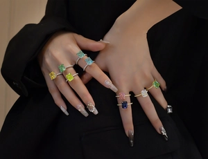 Macro shot of multi-colored ice-cut gemstones set on s925 silver rings worn on hands