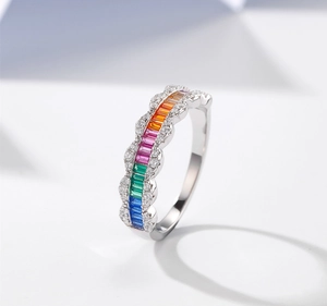 Detail of wavy silver ring featuring gradient rainbow gemstones and micro-pave diamonds