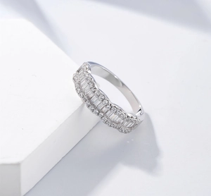 Macro shot of wavy 925 silver ring with baguette and round cut colorful diamonds