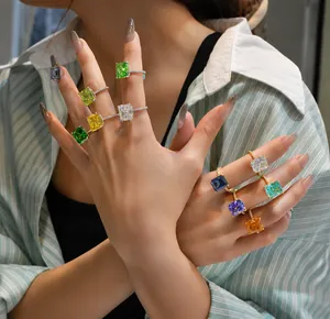 Close-up of colorful rectangle cut gemstone rings with micro-pave silver bands on model