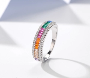 Gros plan d'une bague en argent avec gemmes arc-en-ciel et bordures de diamants
