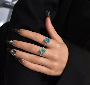 Detail of s925 silver cocktail rings featuring square-cut blue and mint green gemstones