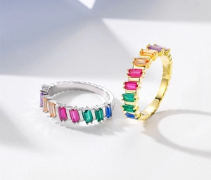 Detail of eternity rings with baguette-cut rainbow gems in silver and gold plating
