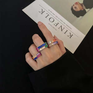 Rainbow baguette cut zircon rings set in gold finish worn by model with magazine