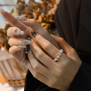 S925 Silberring mit herzförmigen Zirkoniasteinen in Pavé-Fassung an der Hand einer Frau