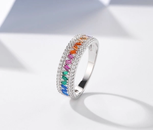 Detailed macro view of silver ring with rainbow gradient baguette gems and micro-pave crystals