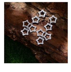 Macro detail of silver star drop earrings featuring hollow tiered pavé zircon stars