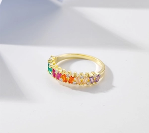 Detailed macro view of rainbow colored rectangular stones and small diamonds on gold ring