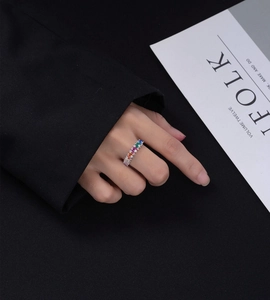Close-up of eternity ring with multicolor baguette-cut crystals on model finger