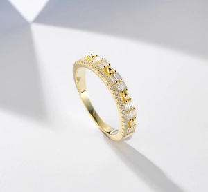 Macro detail of 14k gold-plated silver ring with rectangular zircons on white base