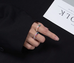 Detail of two S925 silver rainbow rings with colorful rectangular zircon and gold finish