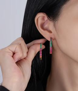 Close-up of rainbow cubic zirconia hoop earrings on model with gold finish C-shape