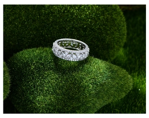 Détail de la bague en argent avec marquise et pierres sur mousse verte