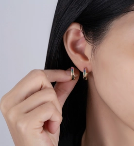 Close-up of 14k gold plated sterling silver hoop earrings with rainbow square cut crystals