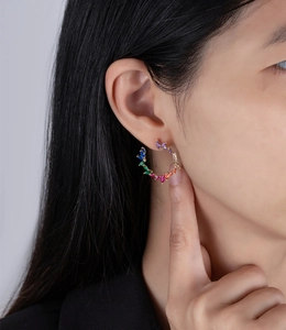 Close-up of olive wreath hoop earring featuring marquise-cut rainbow cubic zirconia