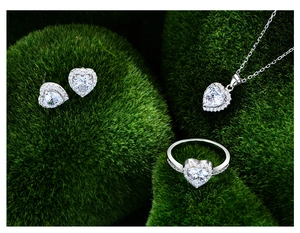 Vista macro di parure cuore in argento 925 con zirconi bianchi su muschio verde