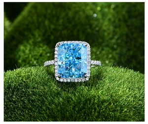 Vue macro d'une bague en pierre bleu clair taille glace sur fond de mousse verte