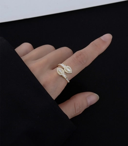 Detail of gold-plated wrap ring with sparkling crystals on wearer's finger