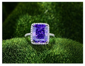 Vue macro d'une bague avec gemme rectangulaire violette 13ct et halo de diamants sur mousse