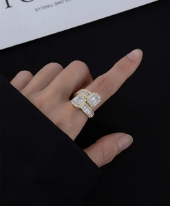 Vue macro d'une bague en argent doré avec pierres taille émeraude et pavé brillant