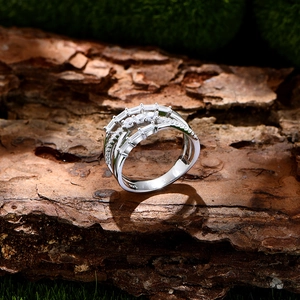 Crossed 925 sterling silver ring with rectangular zircons on natural mossy bark background