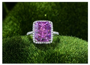 Vue macro d'une bague avec grosse pierre violette rectangulaire et halo de diamants brillants