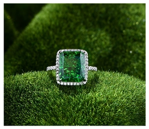 Détail de bague avec pierre verte taille émeraude et pavé de diamants sur argent