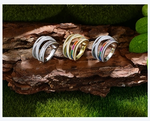 Detailed view of layered sterling silver rings with micro-set diamonds on natural bark
